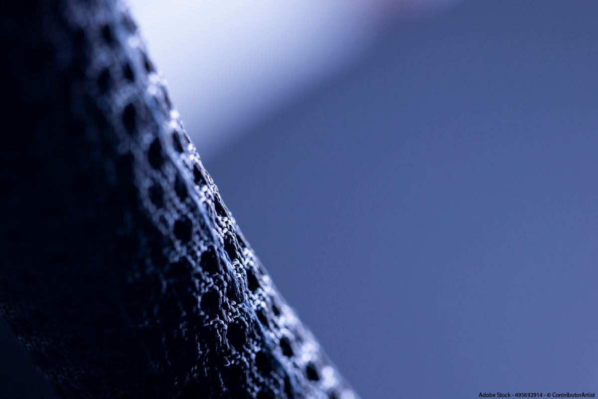 Makroaufnahme einer textilen Oberfläche mit technischer Struktur als Symbol für E-Textiles, intelligente Stoffe und integrierte elektronische Materialien in moderner Textiltechnologie.